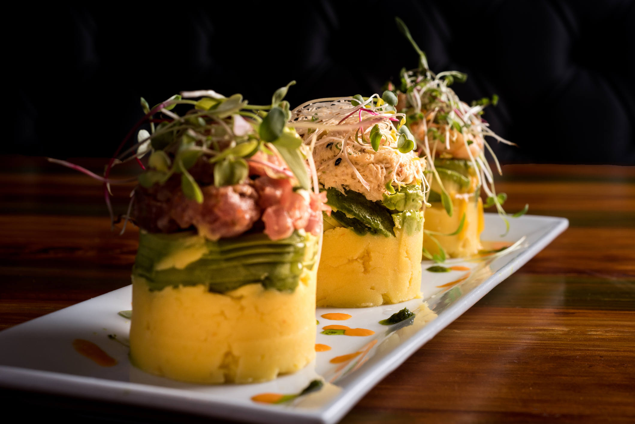 Traditional Peruvian dish called Causa made of mashed potato with aji hot pepper and lime juice and filled with vegetables corn, peas, carrots and mayonnaise 